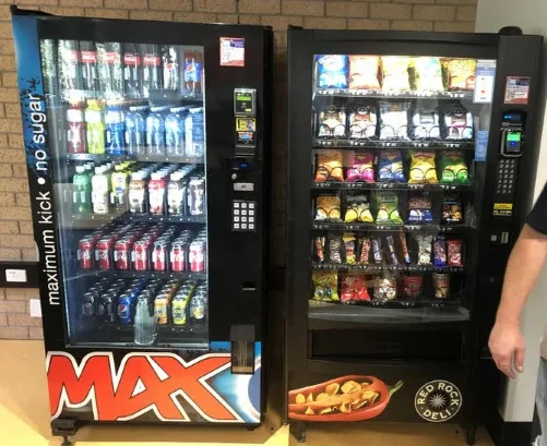 Installed Pepsi Max cold drink vending machine beside a stocked snack vending machine