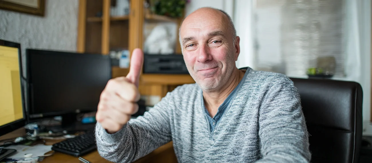 Businessperson at a desk giving a thumbs-up
